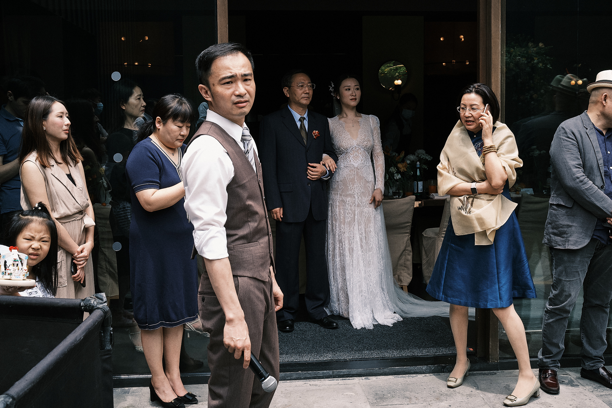 wedding guests and host surround the bride and her father as they prepare to enter the ceremony in shanghai