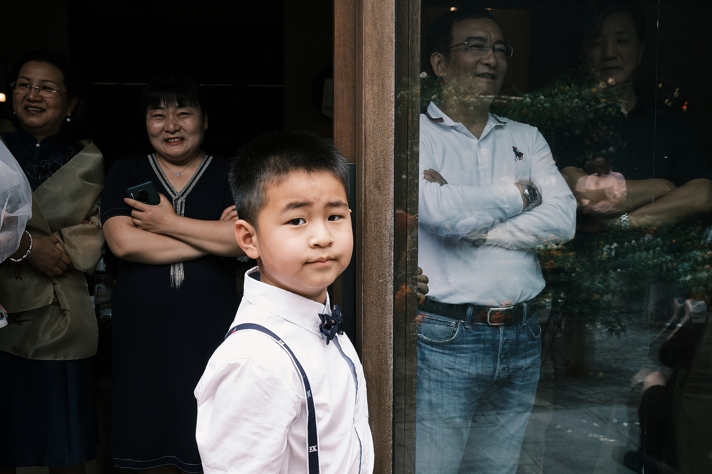 young boy curiously looks at the lens at shanghai wedding