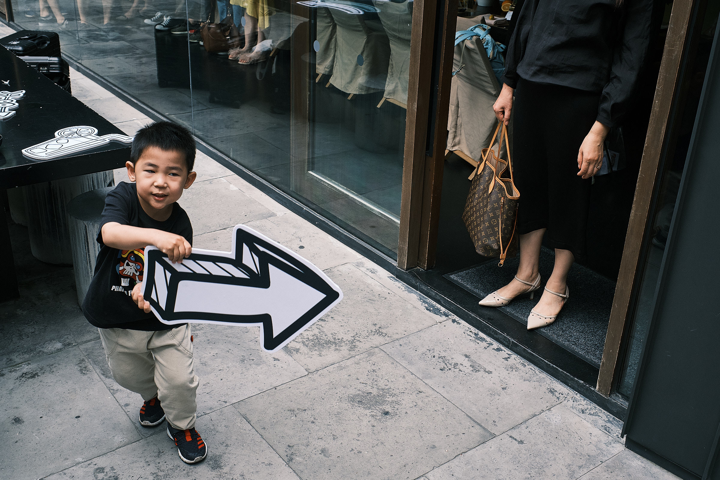 Young Boy With A Paper Arrow Pointing It Towards A Guest