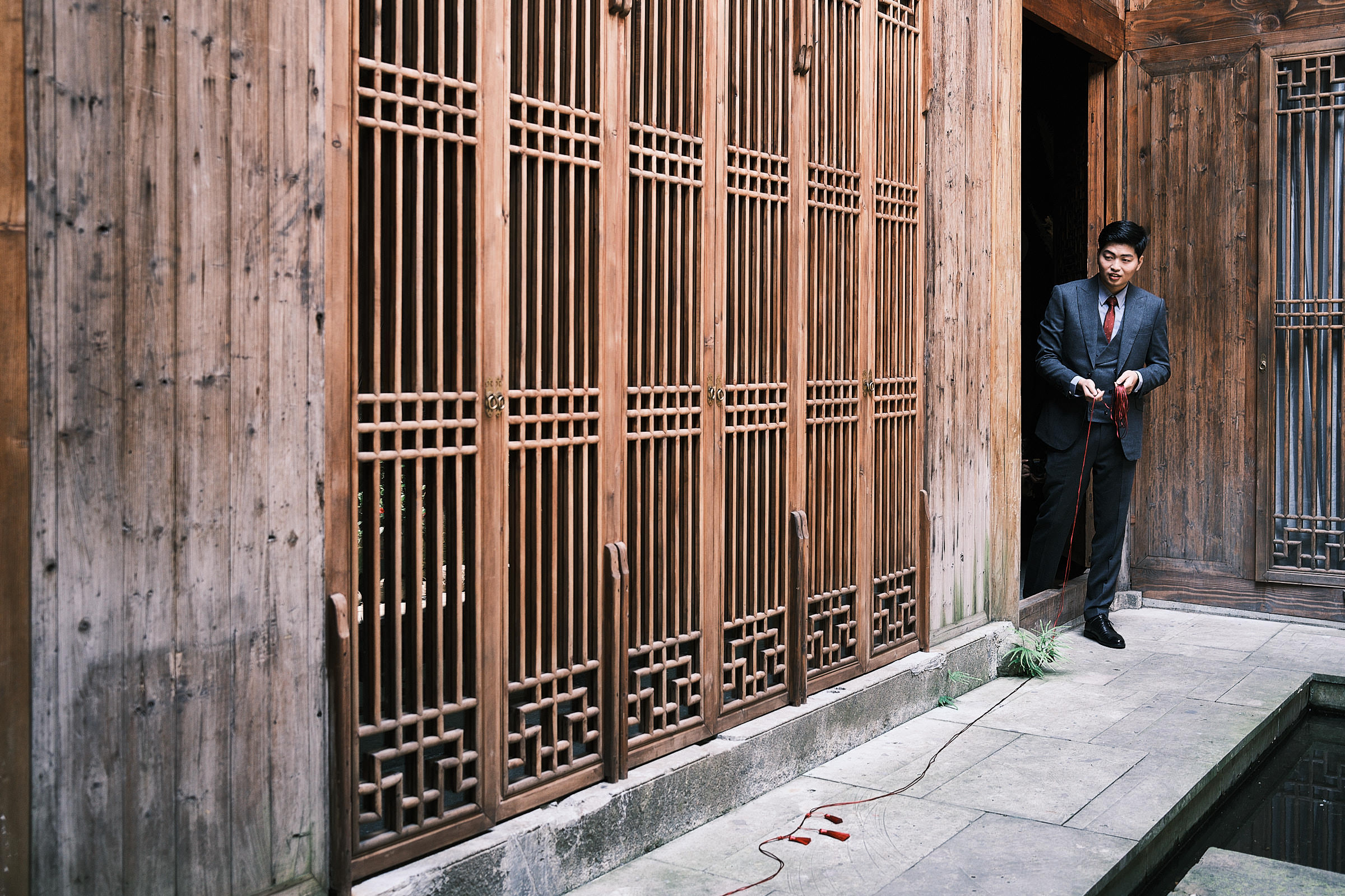 Dressed Up Groom Holds Mystery Red String In China