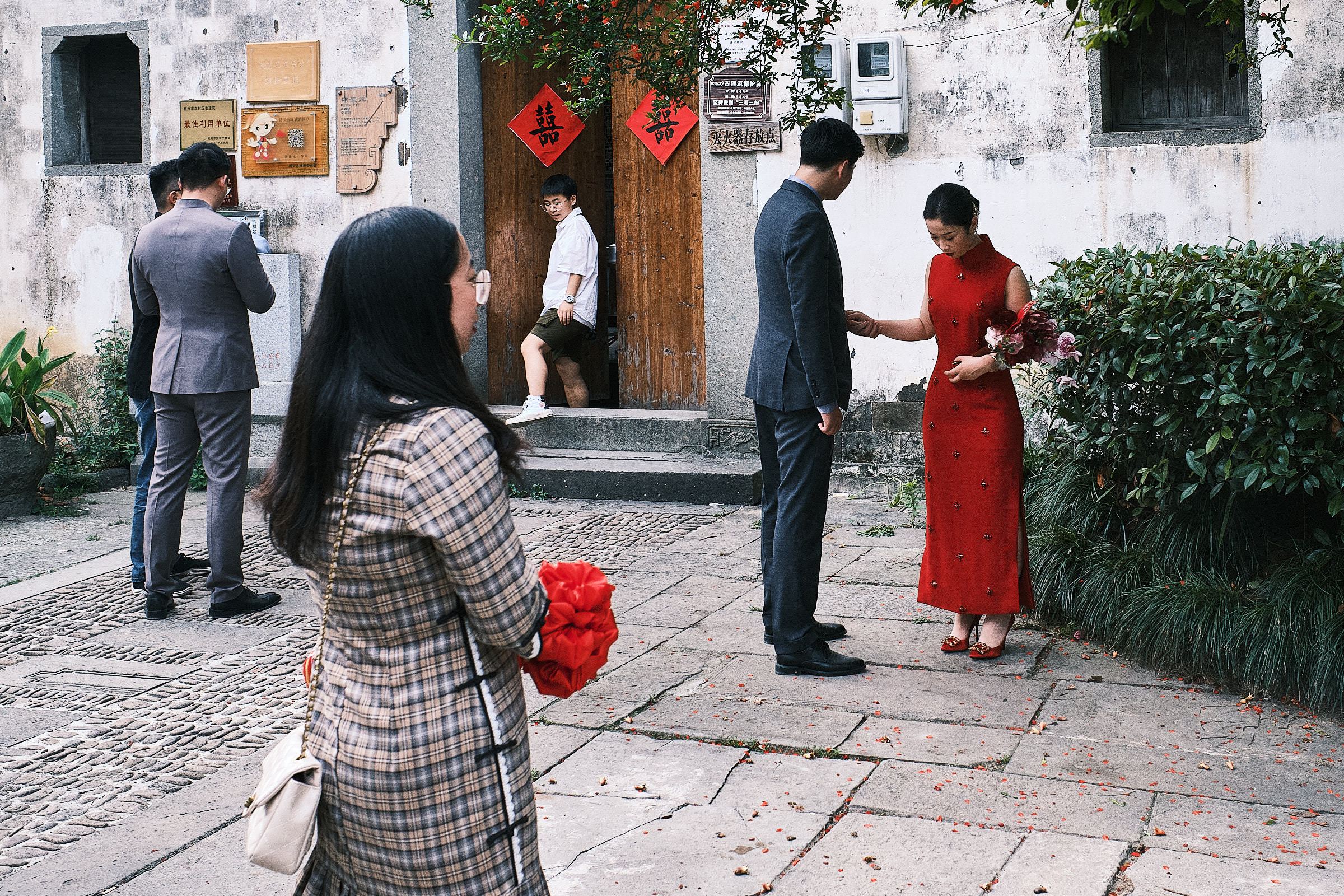 Wedding in Hangzhou bride dressed in red and guests wait outside of ceremony location
