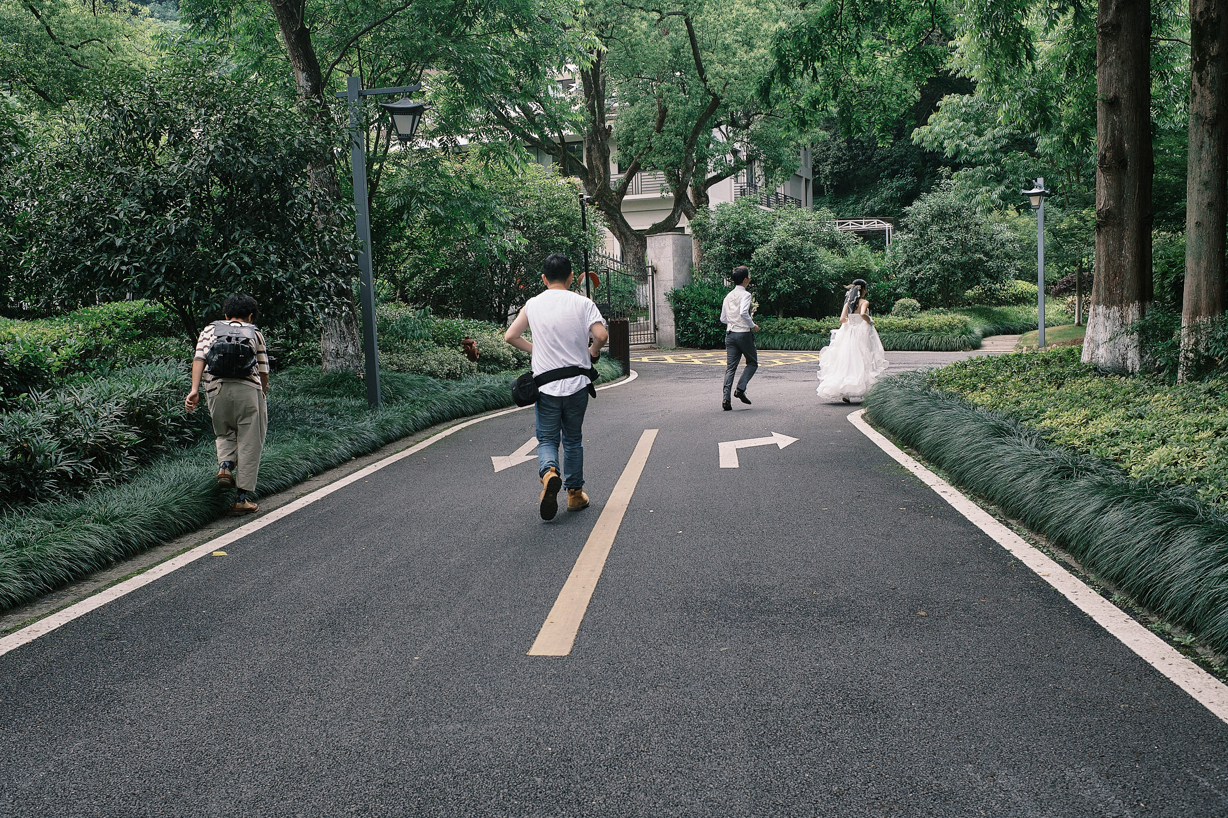 bride and groom run following arrows on the floor as videographer runs after them