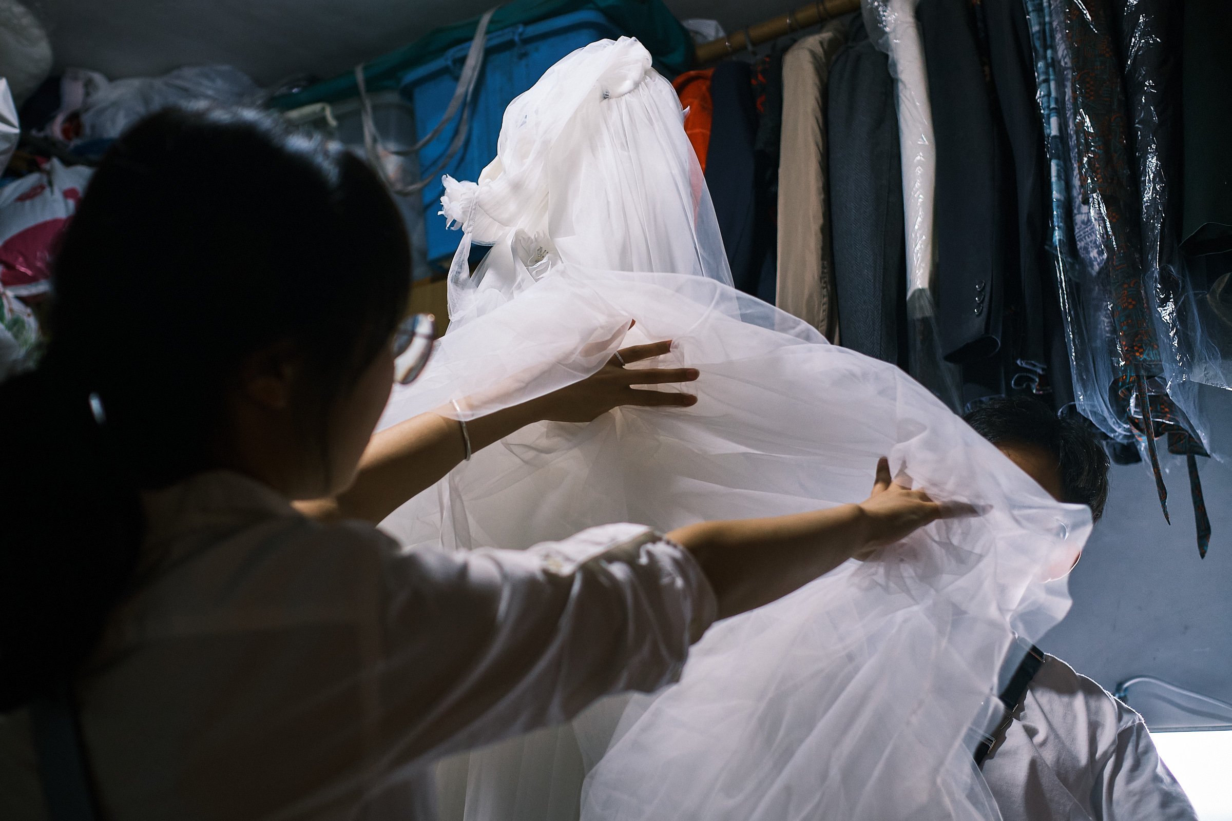 Bride Covers Face Of Groom With Her Dress