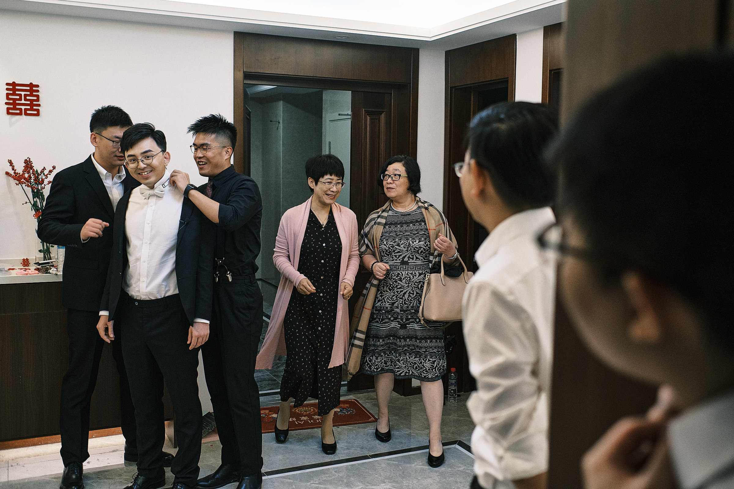 Groom Wears His Jacket With The Help Of His Friends As Family Members Arrive