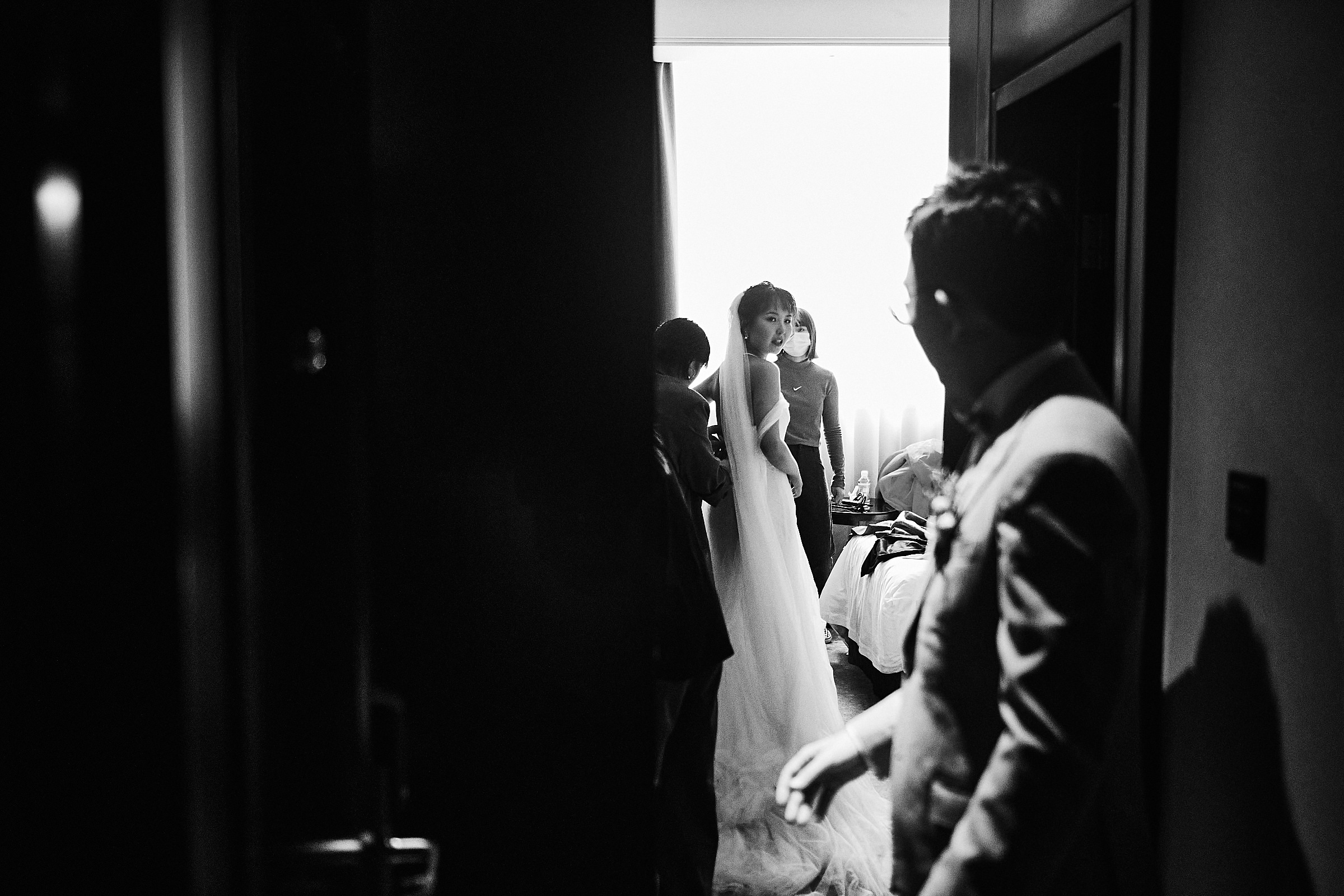 Bride Is Fixing Details Of Her Dress As Groom Looks At Her