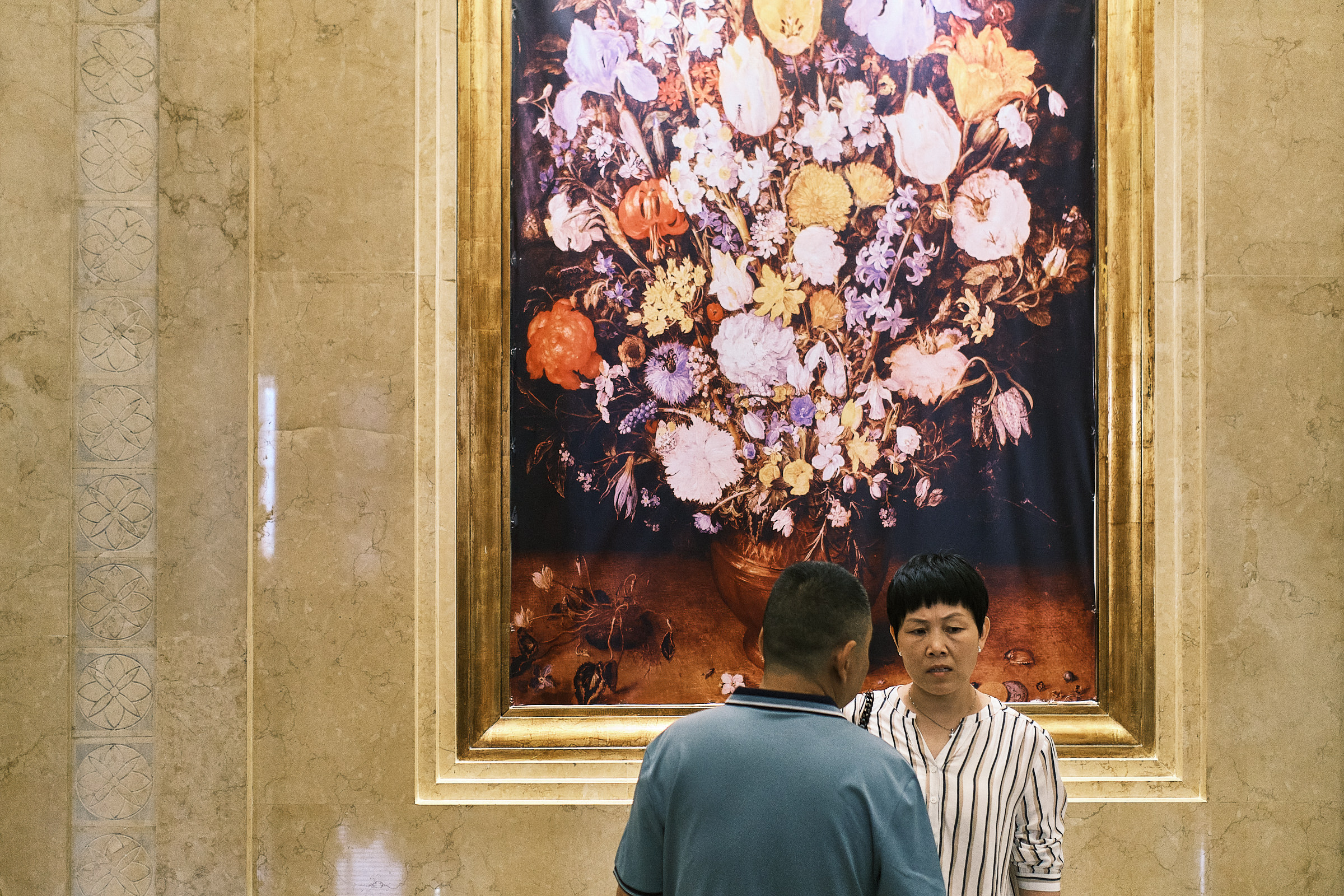 Guests Stand In Front Of Flower Painting