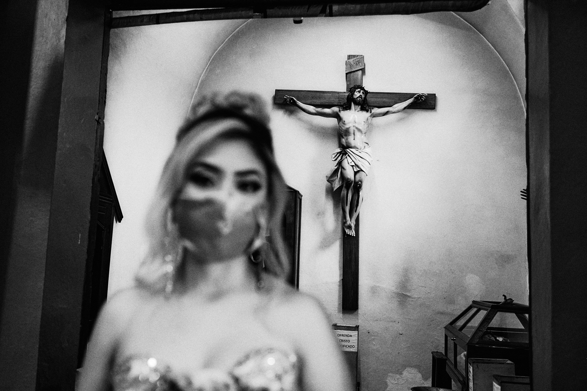 Crucifix In The Background With A Bridesmaid Looking Directly At Camera
