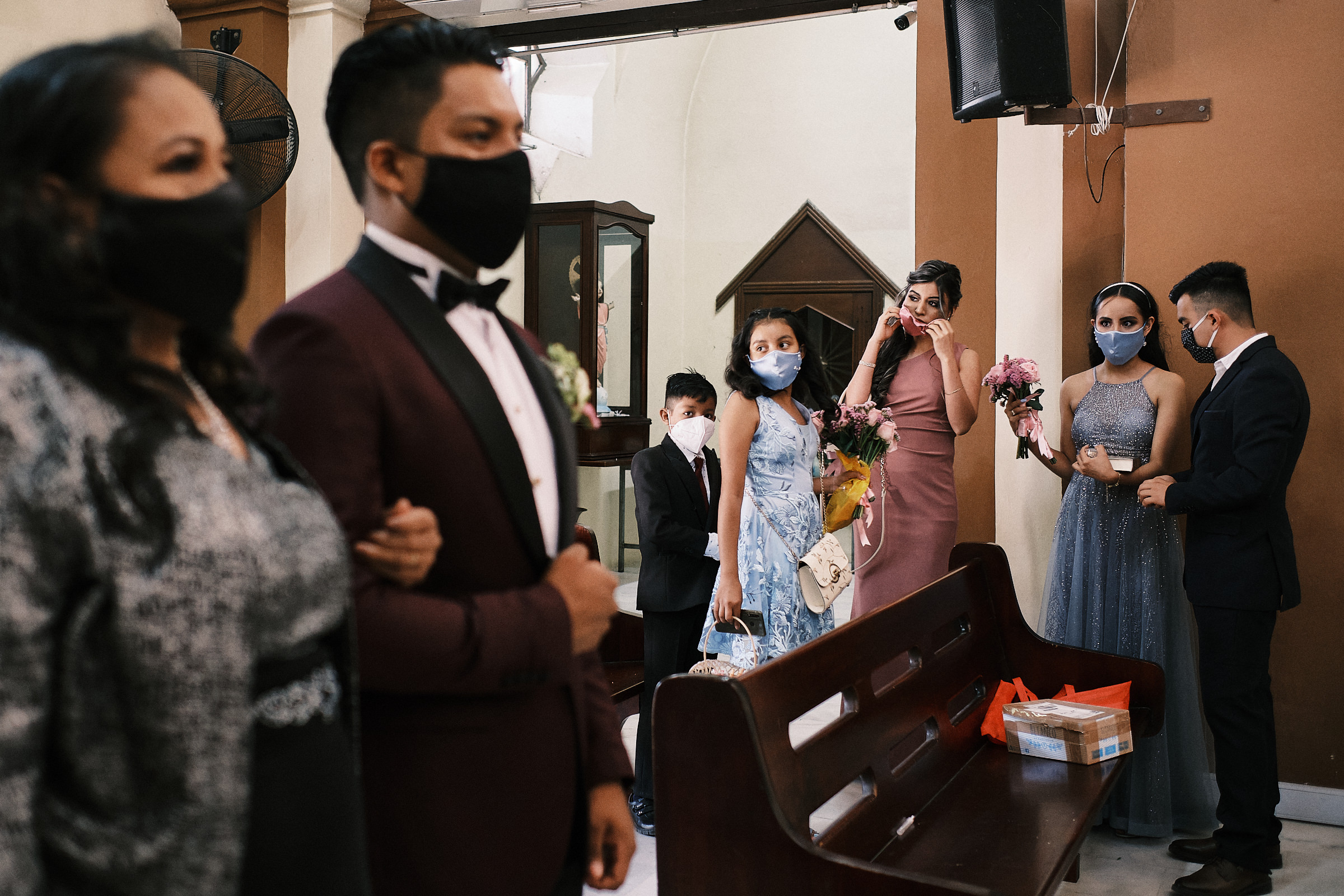 Groom Holds The Arm Of His Mom While Bridesmaid And Guests Get Ready For Ceremony In Mexico