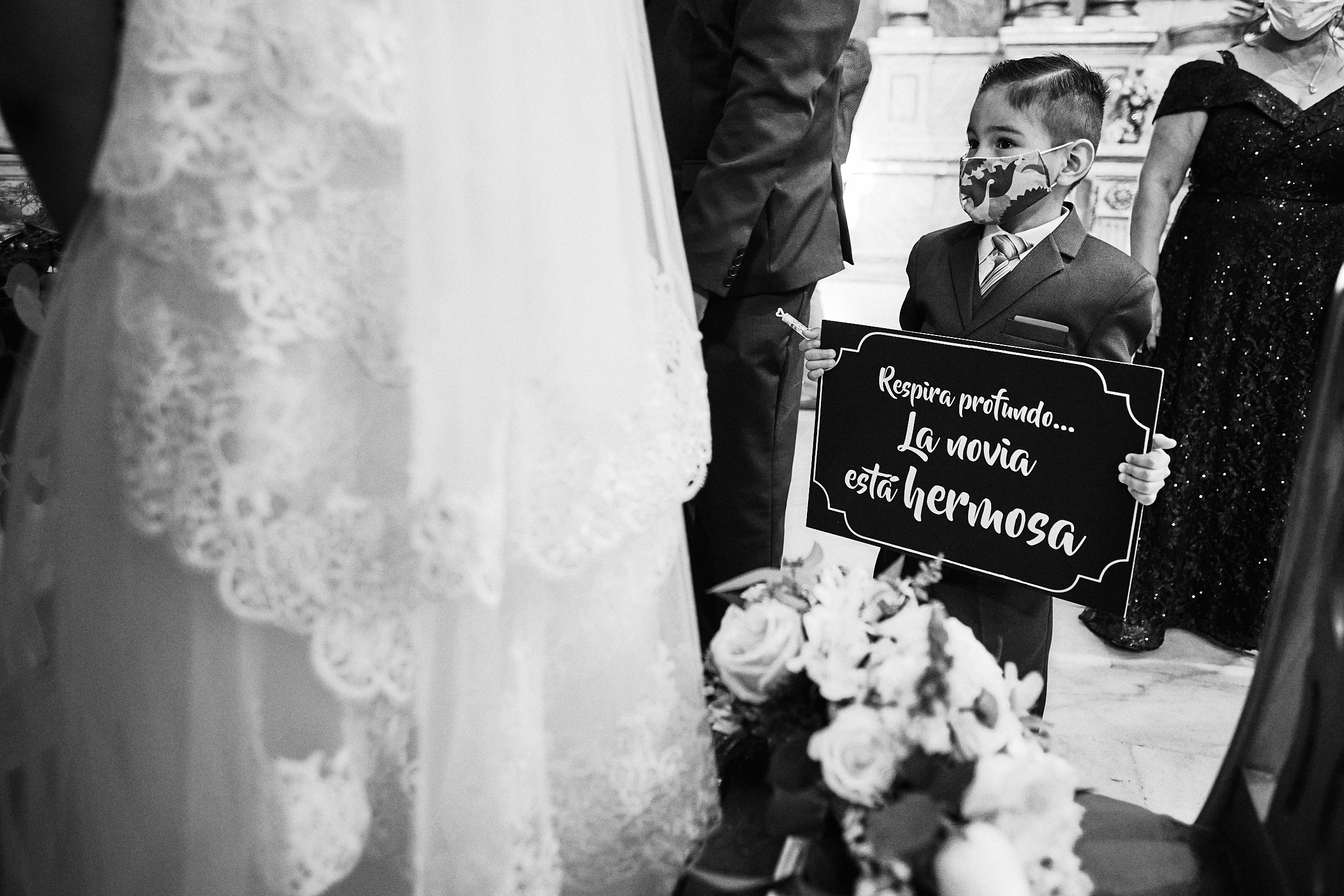 Young Child Holds Sign That Says The Bride Is Beautiful During Ceremony