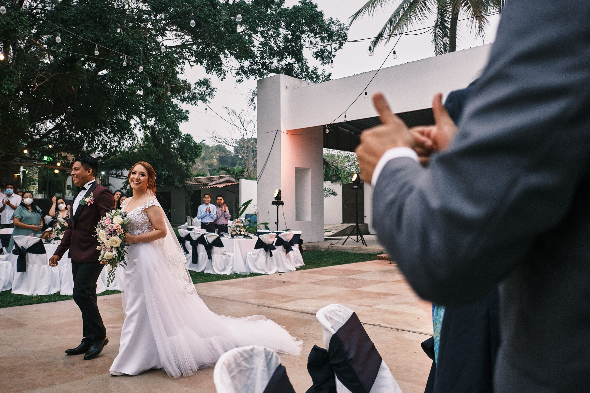 Bride And Groom Walk By A Guest That Gives Them A Thumbs Up
