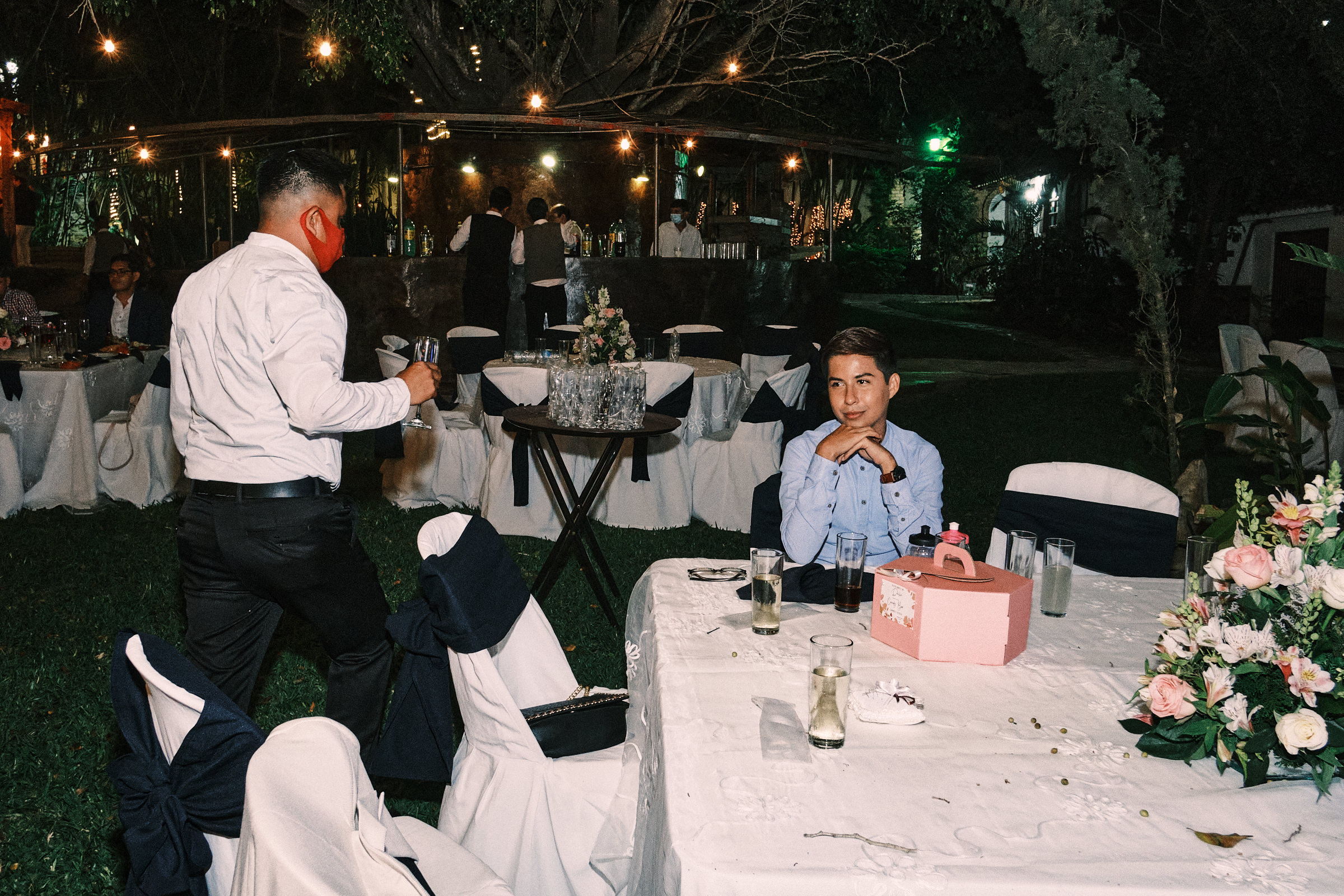 Young Man Happily Waits At His Table During Wedding Reception