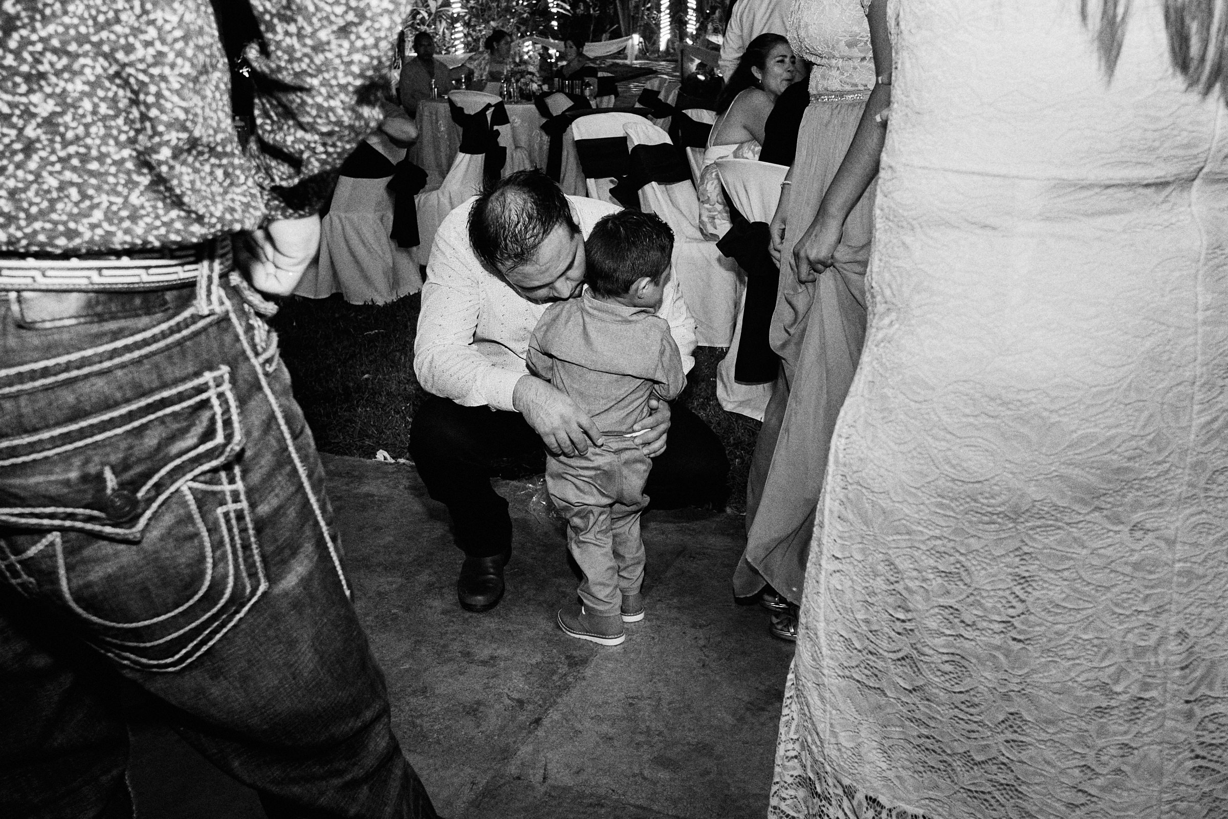 Dad Holds His Child In The Dance Floor In Black And White