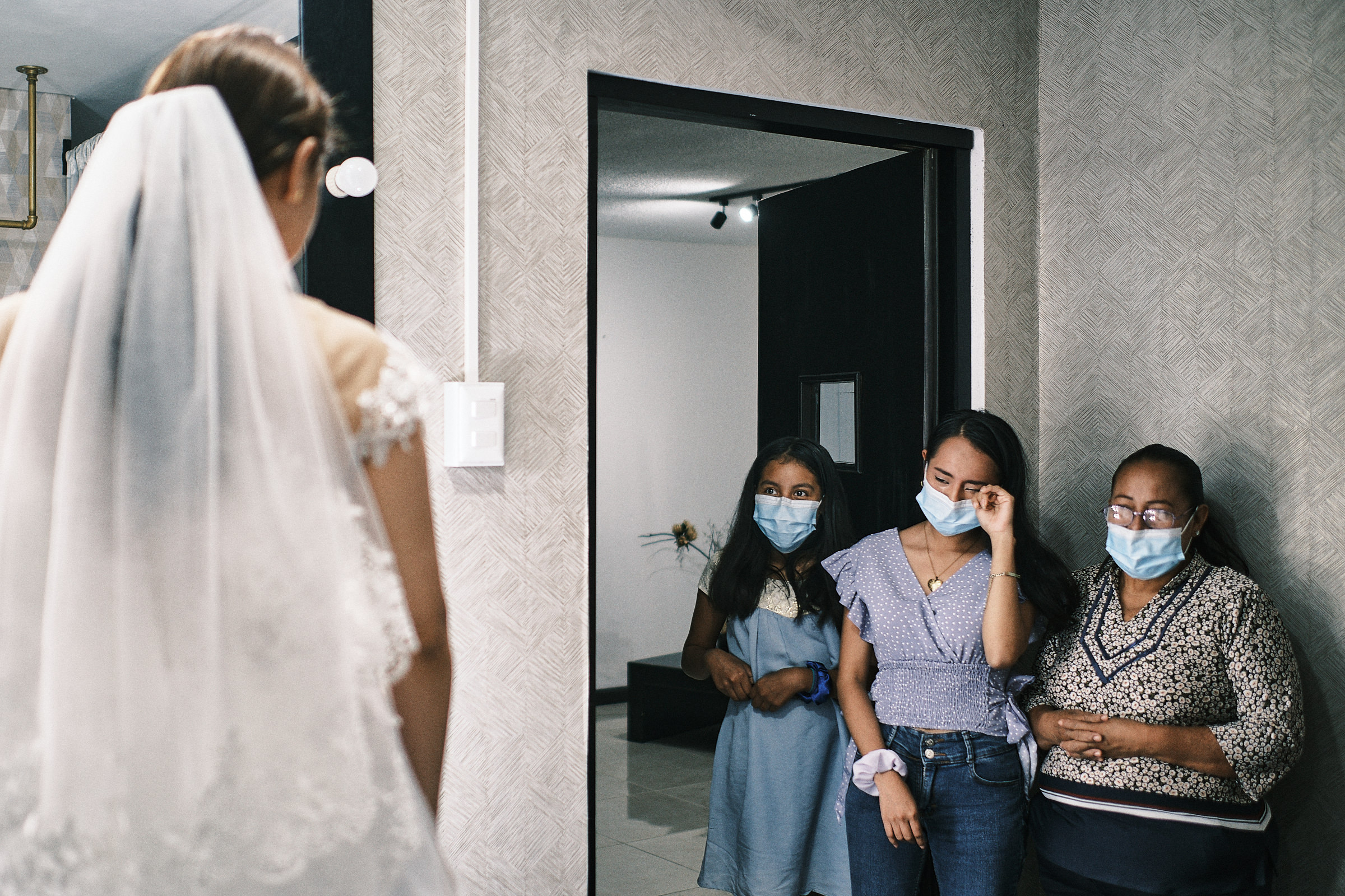 bride shows her dress and sister in law wipes her tears of joy