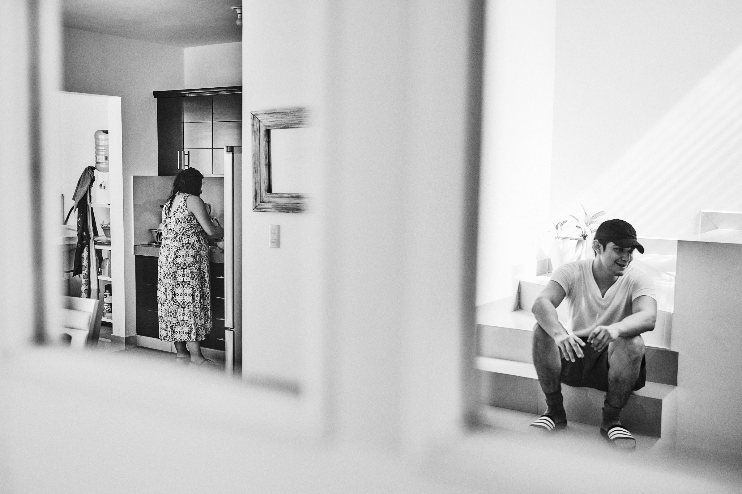 Husband Sits On Steps While Pregnant Wife Prepares Breakfast