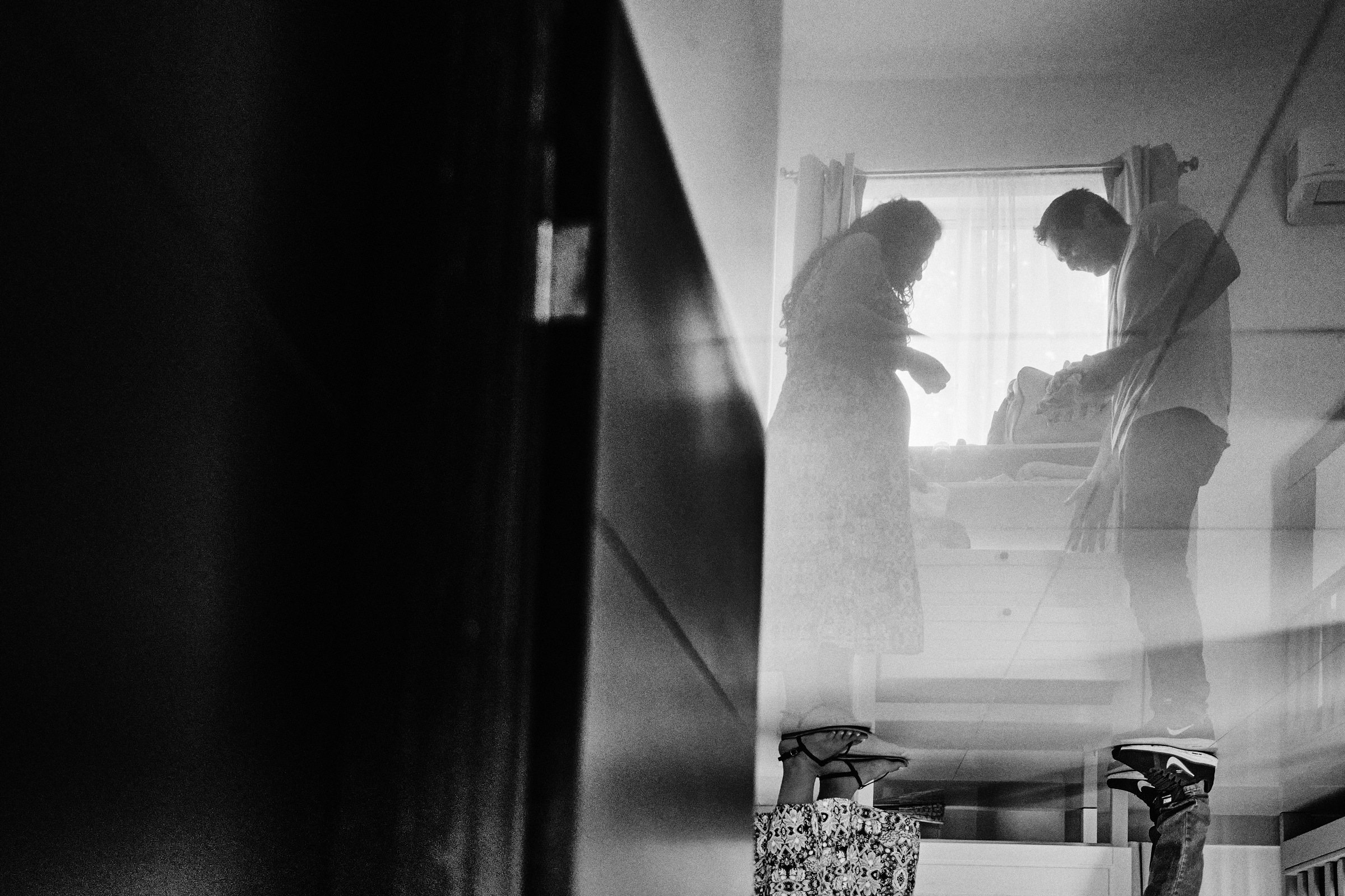 Black And White Reflection Of Husband Helping His Wife Prepare For Arrival Of Baby