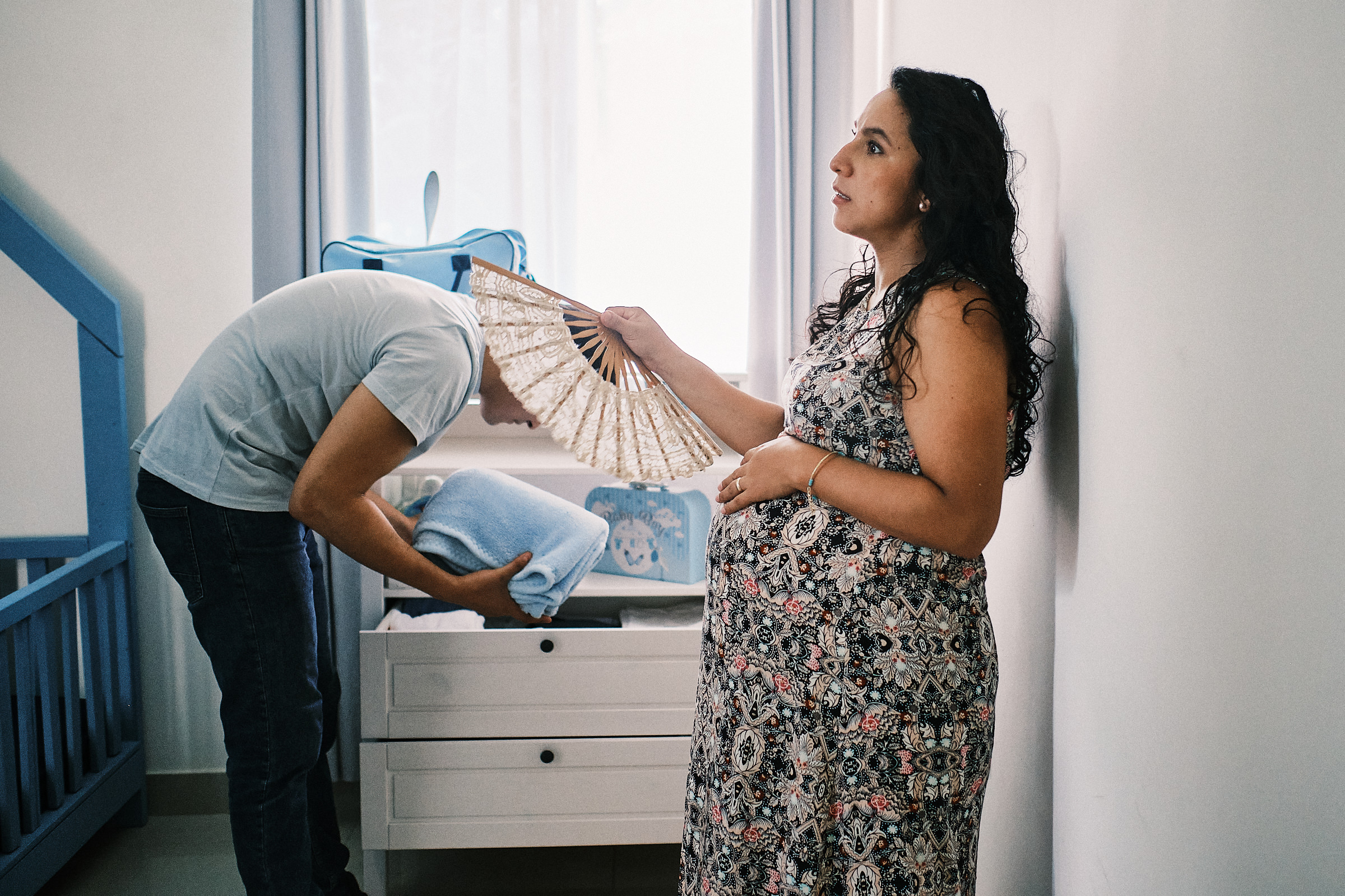 Pregnant Wife Waits As Her Husband Prepares Items For Newborn In Mexico