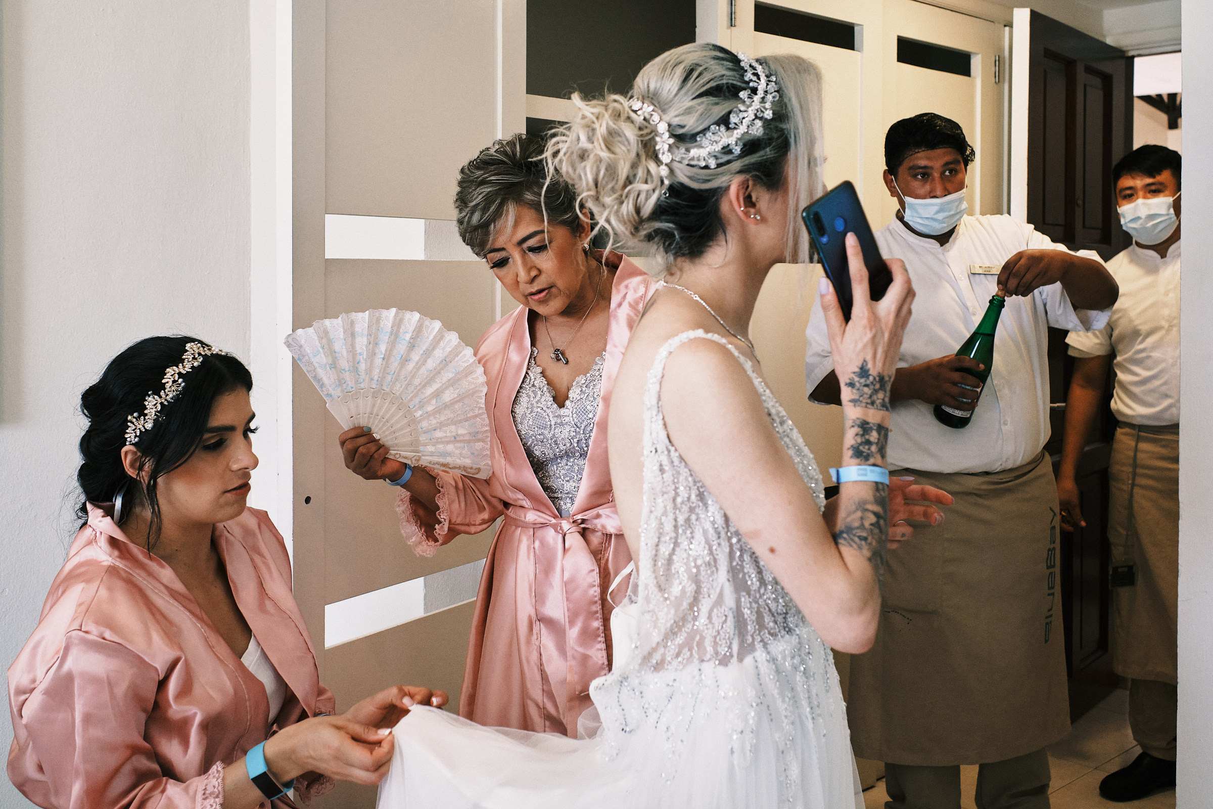 Bridesmaid Fixes The Dress Of Bride As Workers Of Hotel Arrive