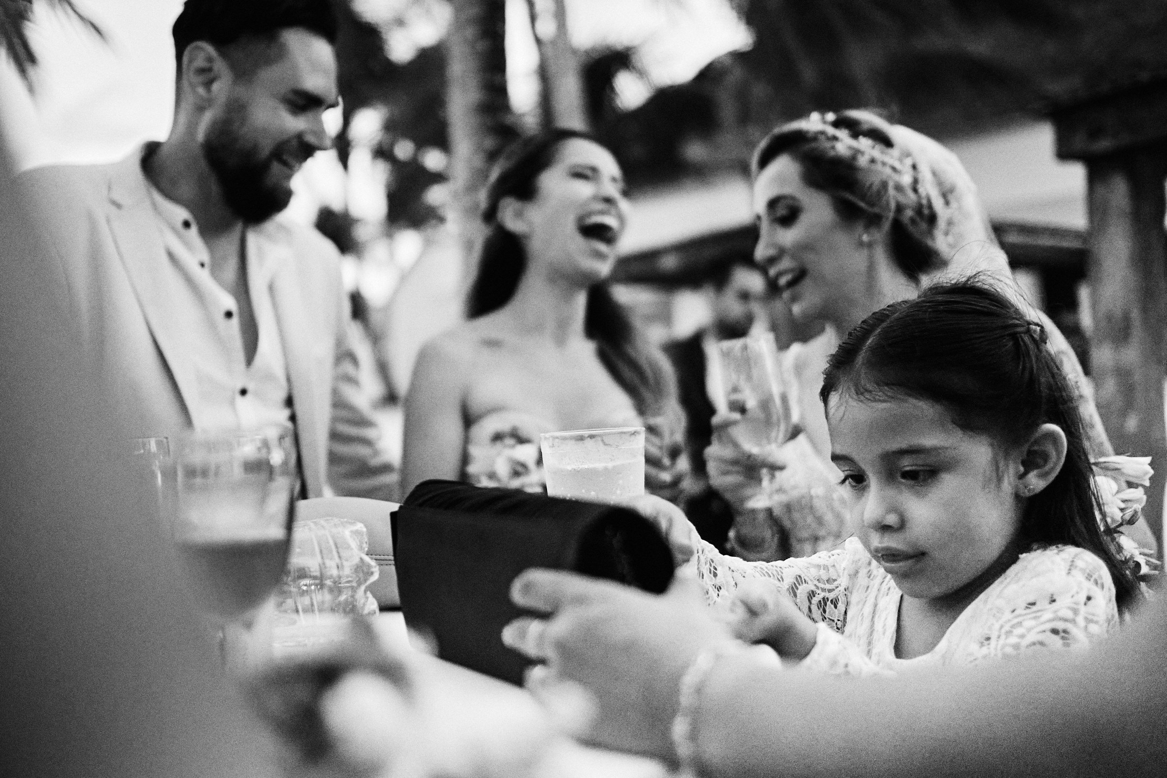 Child Plays On Table As Bride And Guests Laugh In Background