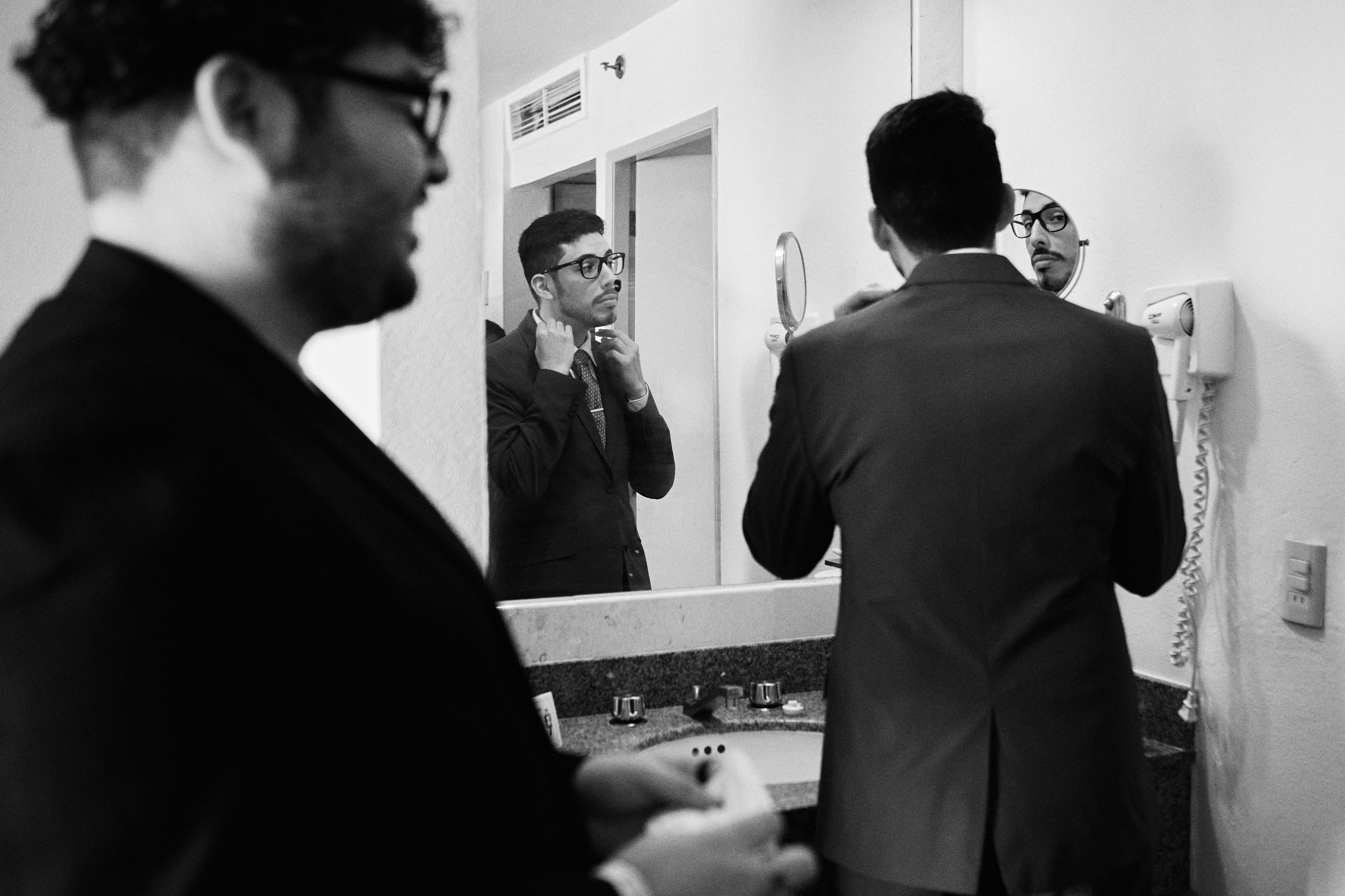 Groom Fixes His Tie In The Mirror The Morning Of The Wedding