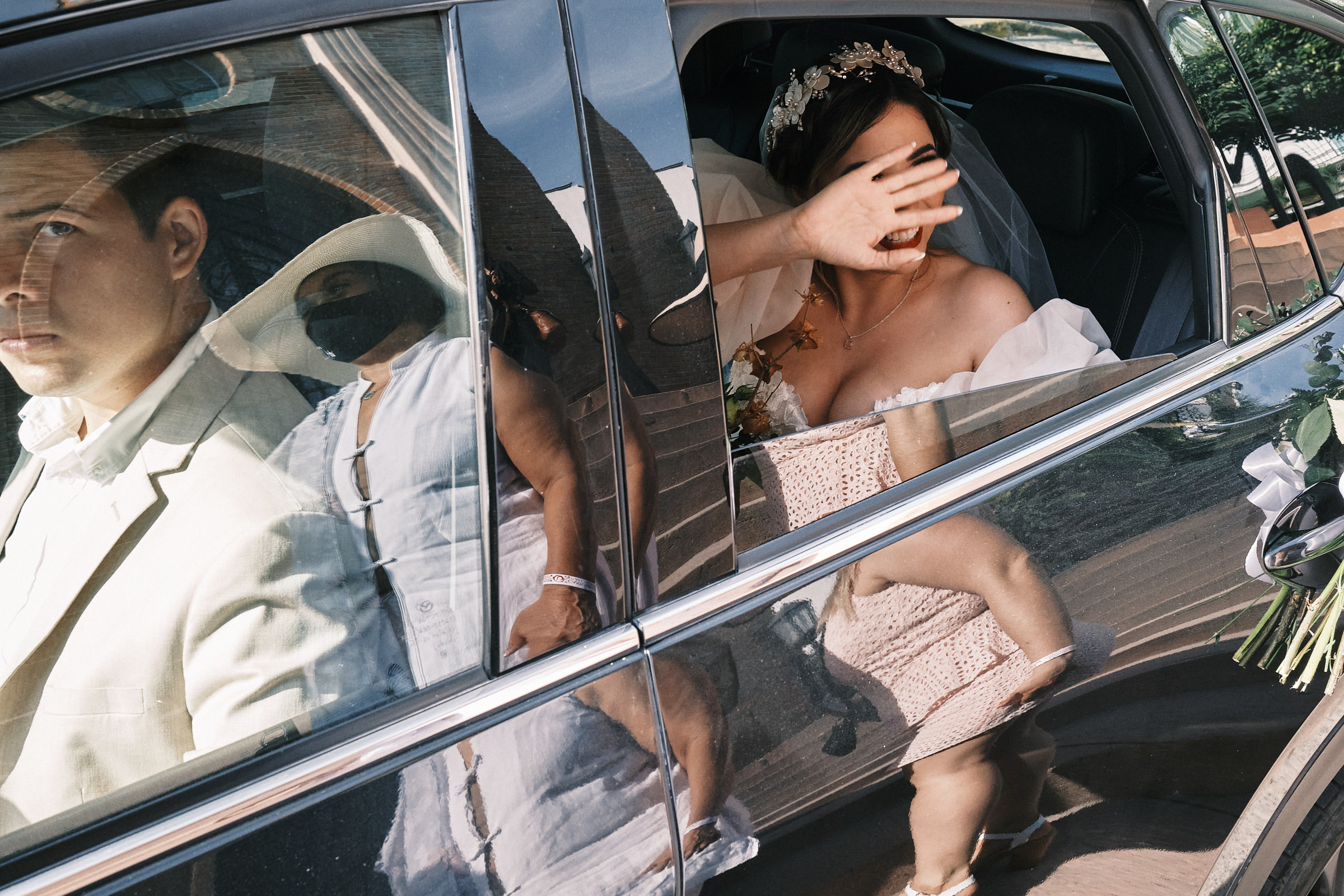 Bride Waves From The Inside Of The Car As She Arrives To Her Ceremony Location