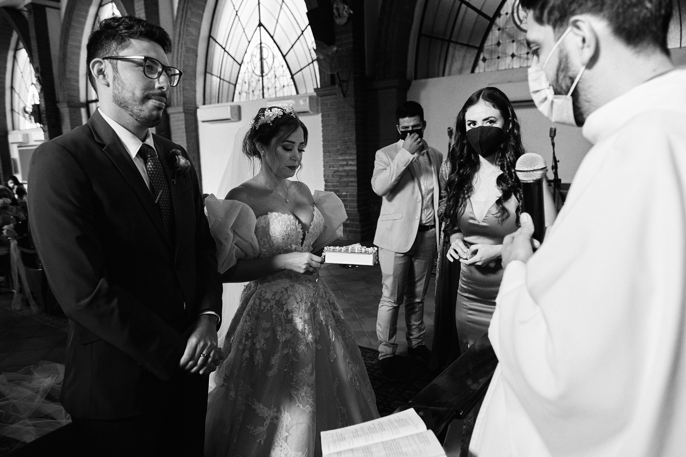 Black And White Photo Of Bride Holding Bible In The Middle Of Catholic Ceremony