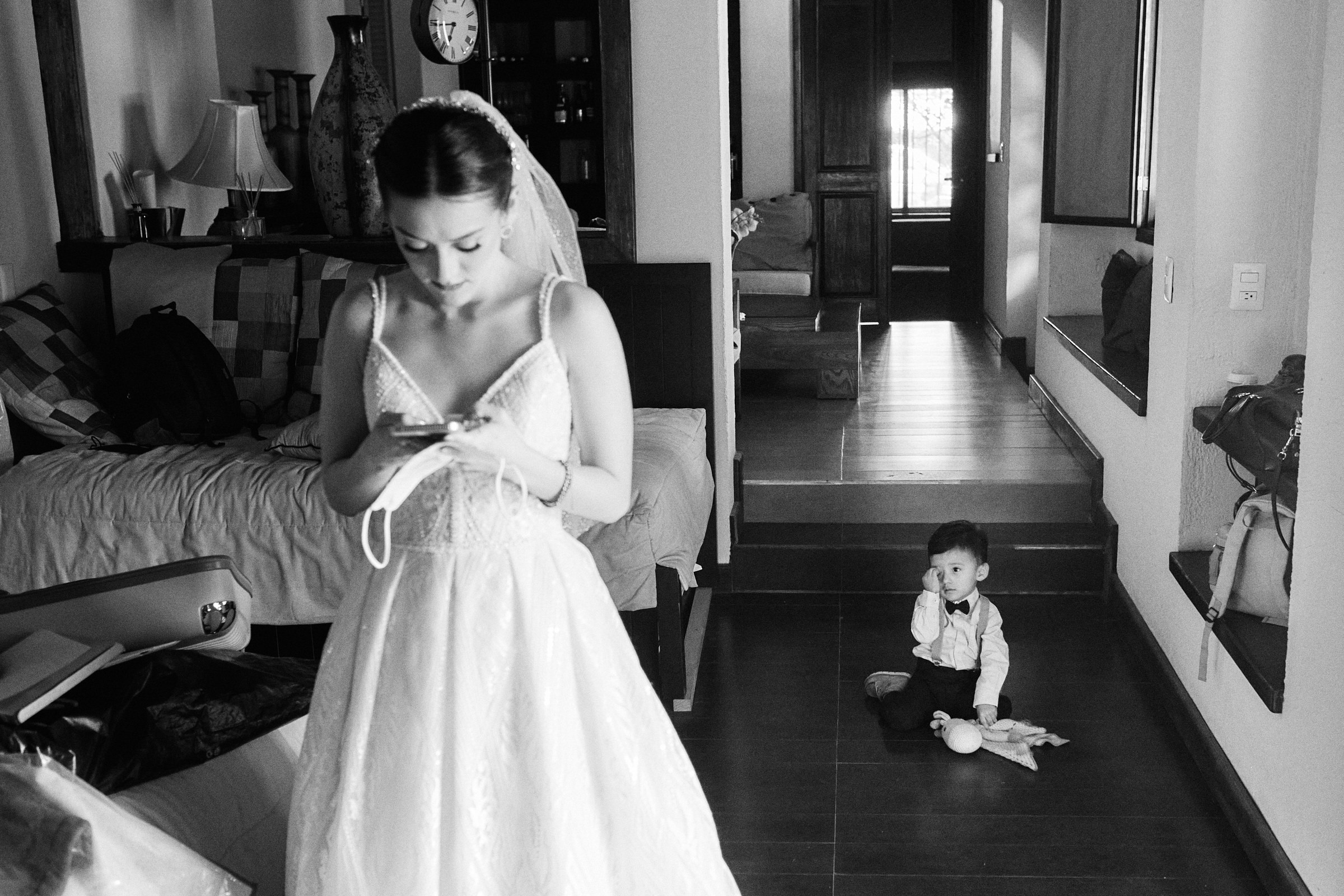 Black And White Photo Of Little Boy Looking At Bride On Her Phone