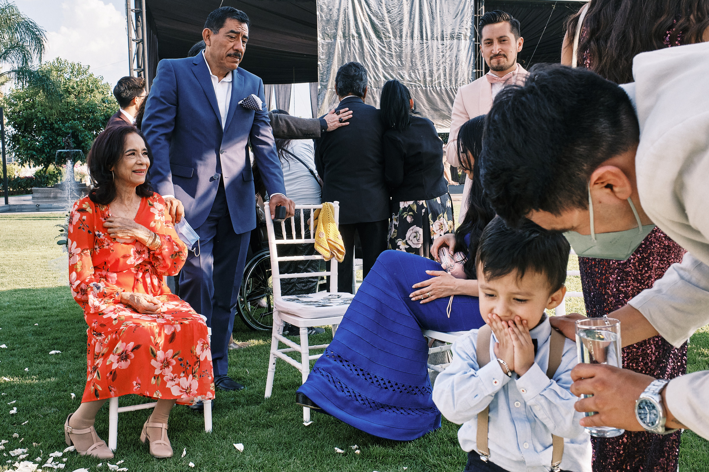 Little Boy Covers His Mouth As Wedding Guests Chat In The Background In Atlixco