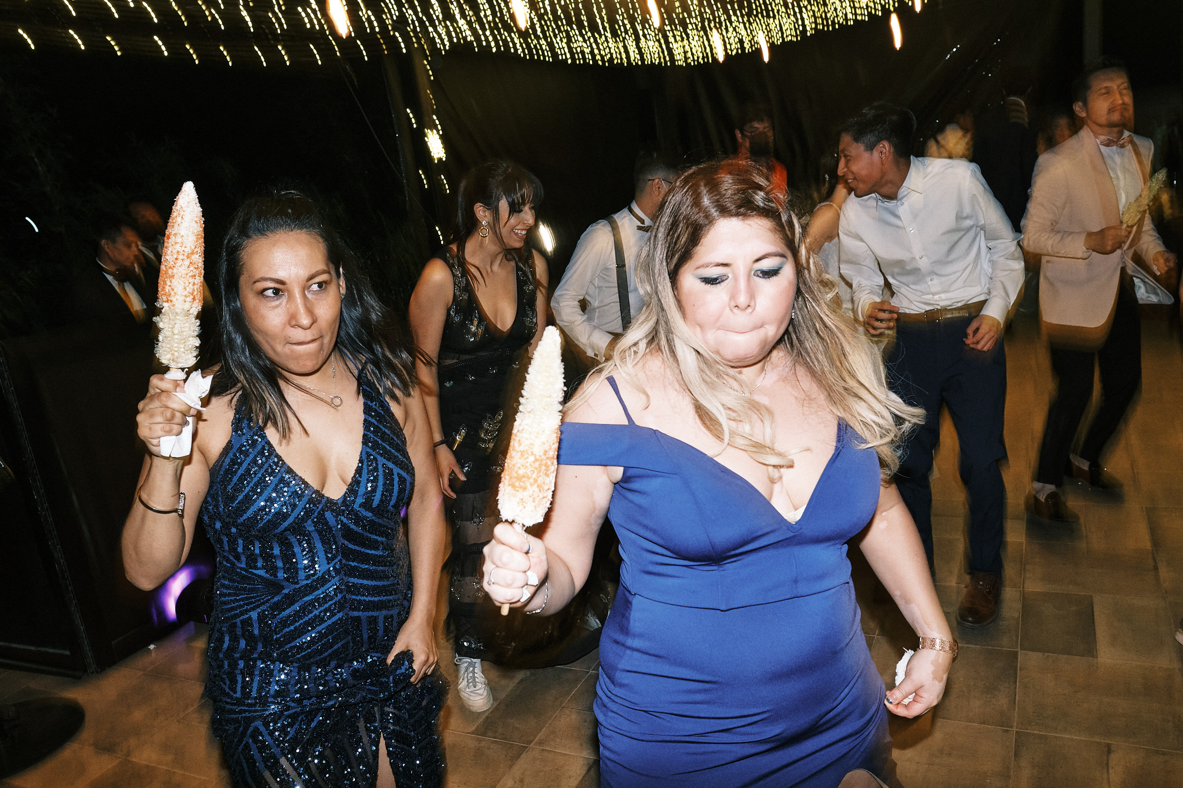 Wedding Guests Dance While Holding Corn In Mexican Wedding